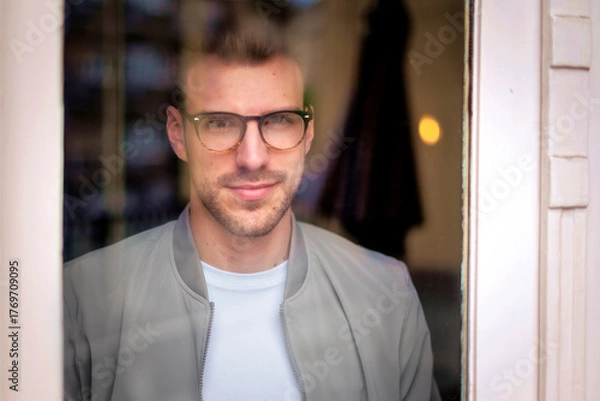 Obraz Portrait of a young man standing indoor and smiling