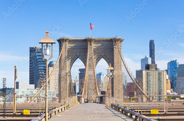 Fototapeta The pedestrian section of the Brooklyn Bridge in New York City is empty of people during the day.