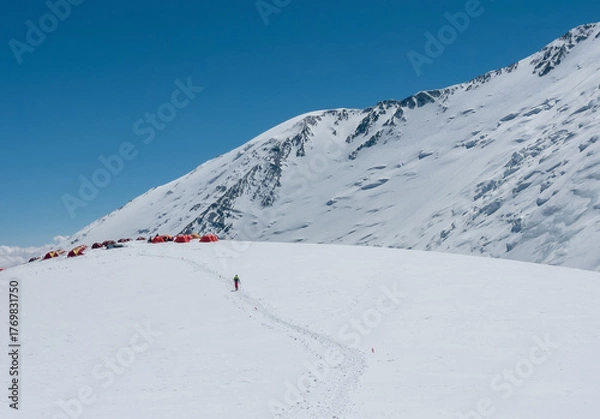 Fototapeta Camp 3 at 6100m. Red tents stand on snowy hill with vast panoramic view of Lenin peak Pamir mountains slopes. Active people concept. Lenin peak expedition route in Kyrgyzstan, Central Asia.