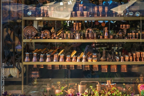 Fototapeta Traditional Turkish cezves and ibriks displayed in shop window alongside copper coffee sets. Concept of oriental coffee culture, handmade cezve, Turkish coffee tradition, oriental craftsmanship