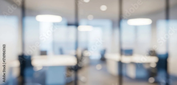 Fototapeta Blurred modern office interior with glass partitions and bright lights, capturing a contemporary corporate atmosphere filled with elegant reflections and a dynamic professional mood.
