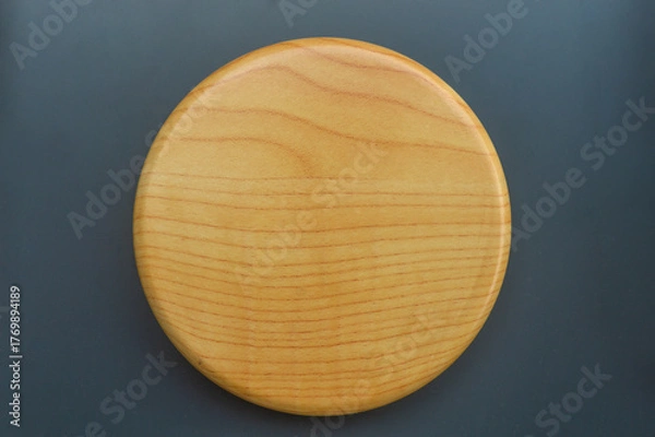 Obraz Top view of a blank circular wooden with visible wood grain texture, isolated on a dark gray background. Ideal mockup for product display, food presentation, and minimal design.