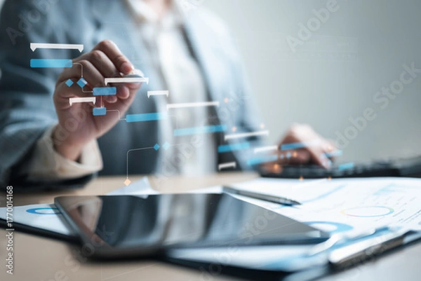 Fototapeta A business person managing a digital Gantt chart on a tablet represents project planning, scheduling, and task management for workflow efficiency and progress tracking.