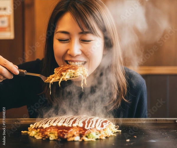 Obraz 湯気立つお好み焼きを頬張る幸せな日本人女性：絶品グルメと笑顔の瞬間