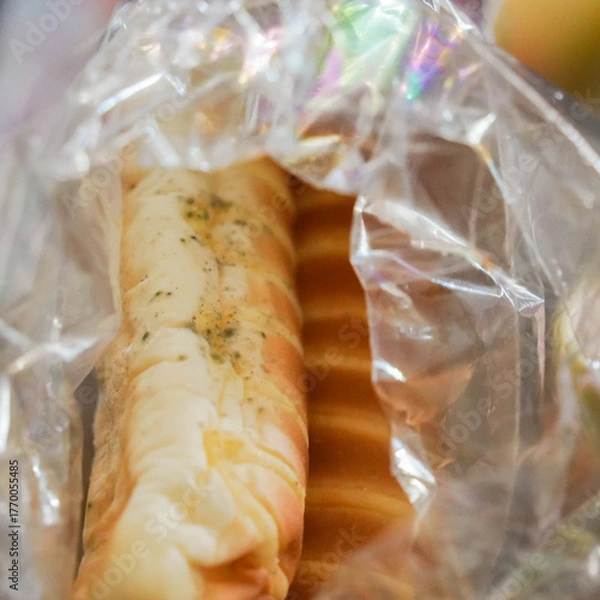 Fototapeta Moldy bread in an open cellophane bag. Bread, unsuitable for food. Mold due to improper storage of the product. Mold stains on bread. Selective focus. close-up.