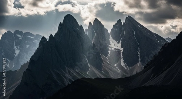 Fototapeta Dramatic Mountain Peaks Under Cloudy Sky with Light Rays