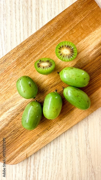 Obraz Mini kiwi berries basking on rustic board, vibrant antioxidant gems, exploring exotic flavors, Kiwi Fruit Festival delight