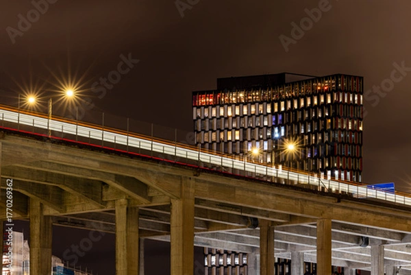 Obraz Stockholm, Sweden A Tunnelbana or Metro train passes on the Skanstull bridge with the STHLM01 building in the background.