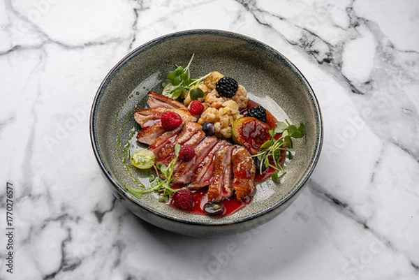 Fototapeta Gourmet duck breast fillet with berry sauce, fresh raspberries, blackberries, figs, grapes, cauliflower and microgreens served on ceramic plate with marble background