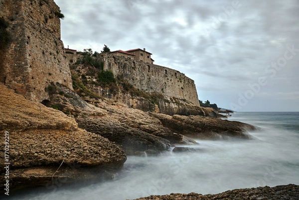 Fototapeta Rocks and stone walls of a medieval castle on the seashore in Ulcinj