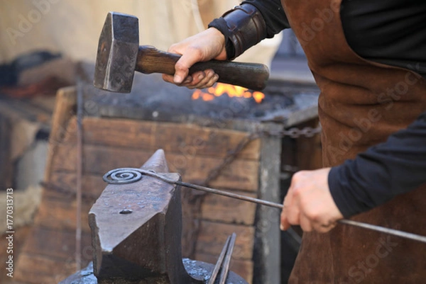 Fototapeta mujer herrera forjadora en el yunque trabajando con el martillo manos forja fuego 4M0A8389-as25