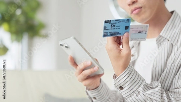 Obraz マイナ保険証を設定するアジア人男性