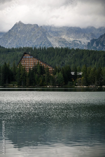 Fototapeta Triangular Building by Lake and Mountains