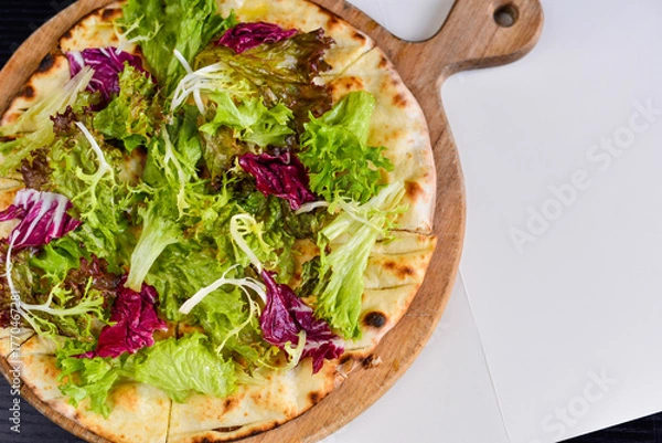 Fototapeta Vegetarian pizza with salad on a wooden board