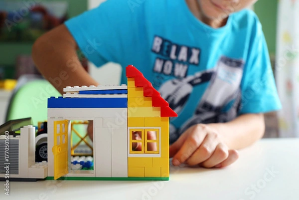 Fototapeta Junge baut mit Bausteinen ein Haus