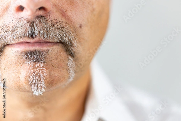Fototapeta Close-up portrait of the lower half of a mature man's face, showcasing a unique and well-groomed facial hairstyle.