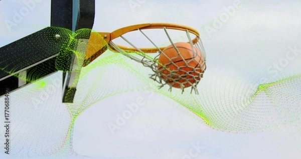 Fototapeta Capturing basketball rim dropping orange basketball through net outdoors, with metal support arm