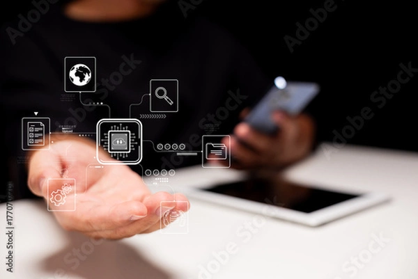 Fototapeta A hand is extended, displaying digital icons and data graphics, while a smartphone lies nearby, symbolizing technology and connectivity.