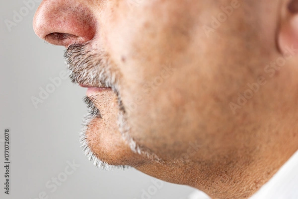 Fototapeta Macro side view of a man’s face showing gray mustache and goatee.