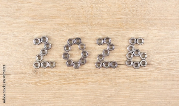 Fototapeta Number 2026 by metal nuts on a light wooden background. 2026 year