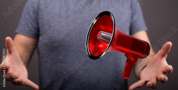 Obraz A man's hands cradling a red megaphone, symbolizing announcement, communication, and important message delivery.