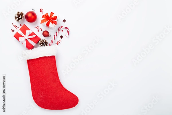 Obraz Christmas sock with gifts and decoration on color background, top view