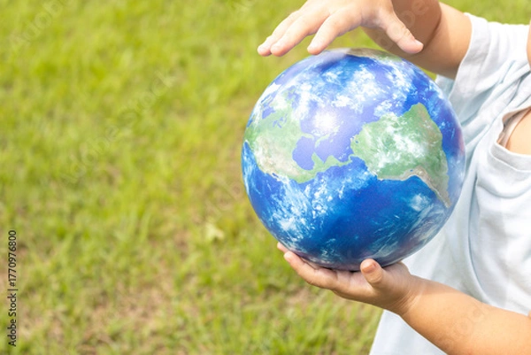 Obraz 地球儀を持って草原で立っている男の子（2歳、日本人、顔無し）