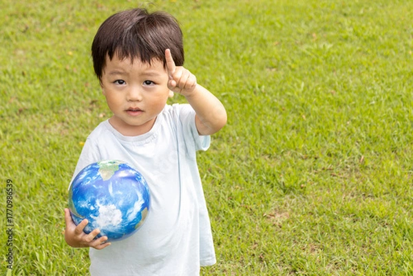 Obraz 地球儀を持って草原で立っている男の子（2歳、日本人、笑顔）