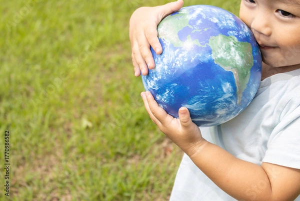 Obraz 地球儀を持って草原で立っている男の子（2歳、日本人、笑顔）