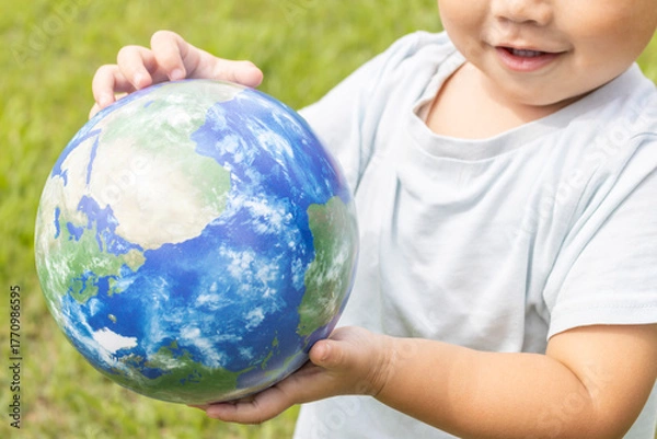 Obraz 地球儀を持って草原で立っている男の子（2歳、日本人、笑顔）
