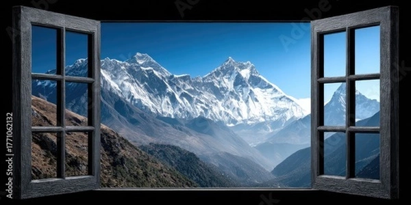 Fototapeta Majestic snow-capped mountains viewed through an open window.