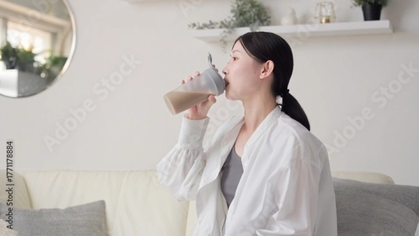 Obraz リビングでプロテインを飲むアジア人女性