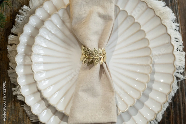 Obraz White plates decorated napkin and golden ring. Overhead view. Elegant crockery.