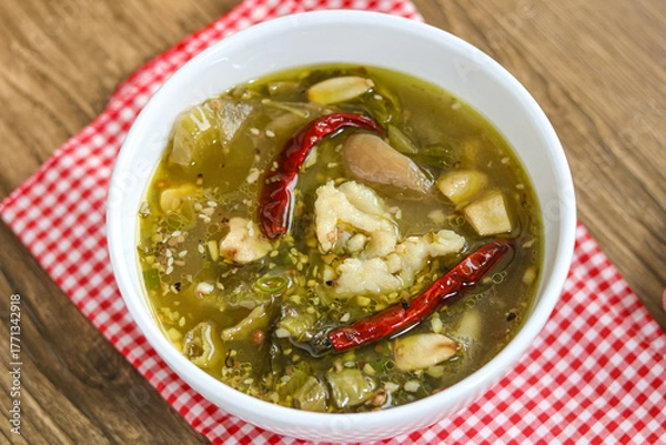 Fototapeta A bowl of Chinese Sauerkraut Fish (Suan Cai Yu), featuring tender fish fillets in a flavorful broth with vegetables and red chili.