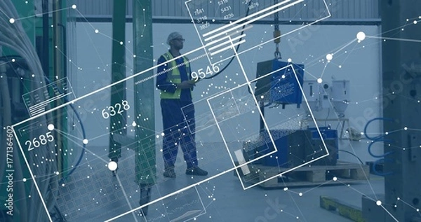 Obraz Factory tech in helmet and vest examining component hanging from crane hook, with data overlays