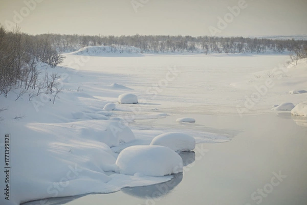 Fototapeta Freezing river with round snowdrifts and steam, close-up. Frosty day, northern winter landscape