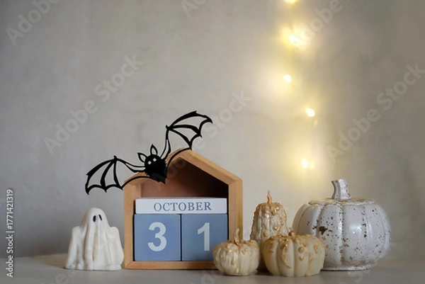 Fototapeta autumn still life. 31 october date calendar, decorative pumpkins, ghost, bat on table close up. cozy festive decor for Halloween, Samhain holidays. idea for fall season interior decoration