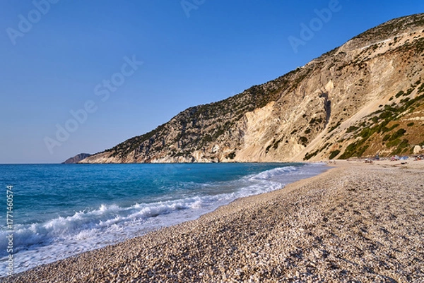 Fototapeta White pebbles on the beach at the foot of a rocky cliff on the island of Kefalonia