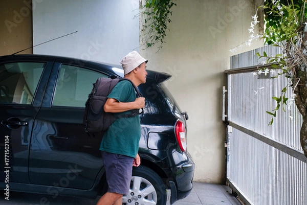 Fototapeta man carrying backpack going out to the park wearing bucket hat