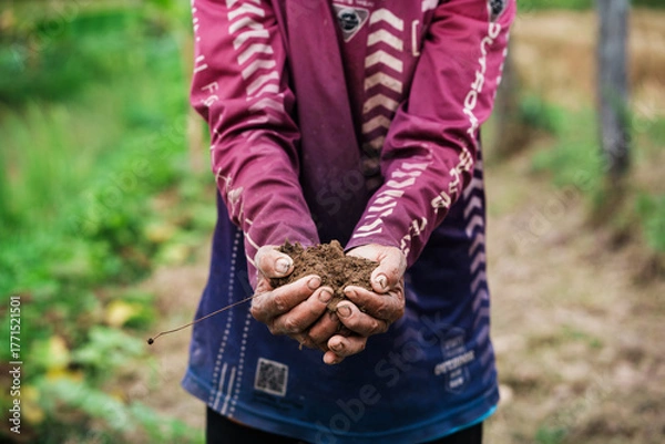 Fototapeta Soil restoration action by hands-on youth in nature outdoor environment close-up viewpoint environmental sustainability