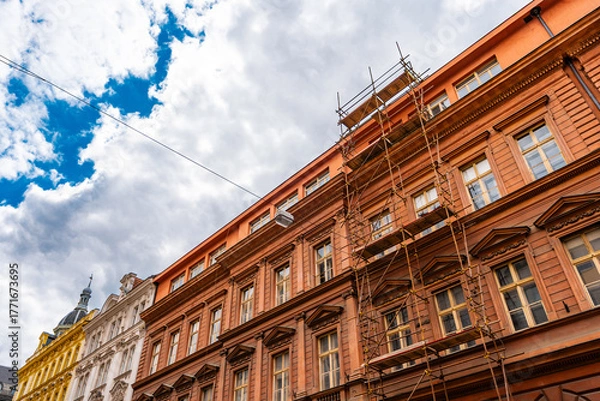 Fototapeta Building Facade Covered with Construction Scaffoldings.