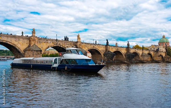 Fototapeta Tourist Cruiser Passing Historic Charles Bridge on Vltava.