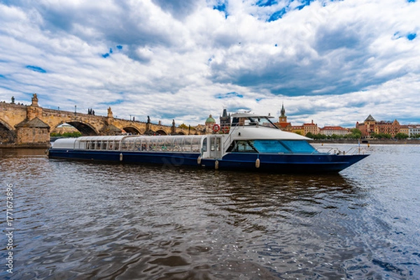 Fototapeta Tourist Cruiser Passing Historic Charles Bridge on Vltava.