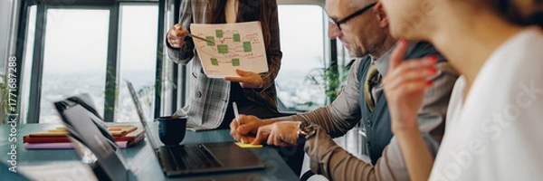 Fototapeta A dedicated team engages in strategic talks while reviewing an innovative presentation in a creative office