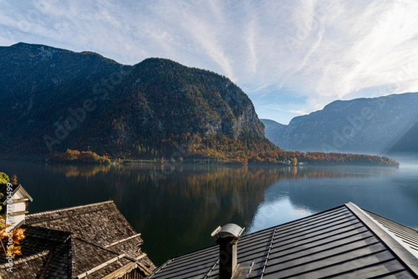 Fototapeta Autumn Mountain Lake Landscape with Colorful Forest Reflection and Traditional Rooftops under Clear Blue Sky