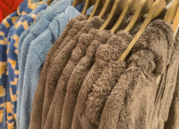 Obraz Fluffy soft teddy fleece jackets on a clothes rack in a department store 
