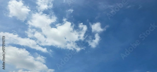 Fototapeta The sky is half cloudy. The clouds are on the left side of the picture while the right side is empty . The sky looks blue. The atmosphere of the sky in summer. White clouds floating all over the sky. 