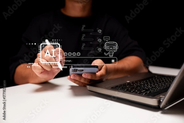 Fototapeta A person interacts with a smartphone while using a laptop, with digital AI graphics overlaying the scene, indicating a focus on technology and innovation.