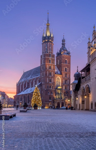 Fototapeta St Mary's church and Cloth Hall fragment on snow covered Main Square in winter Krakow, illuminated in the dawn