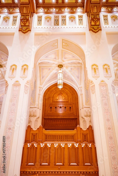 Fototapeta A stunning view of the grand arches, detailed ceiling, and carved wooden panels inside the Royal Opera House in Muscat, Oman. The image captures the exquisite fusion of Islamic geometric design